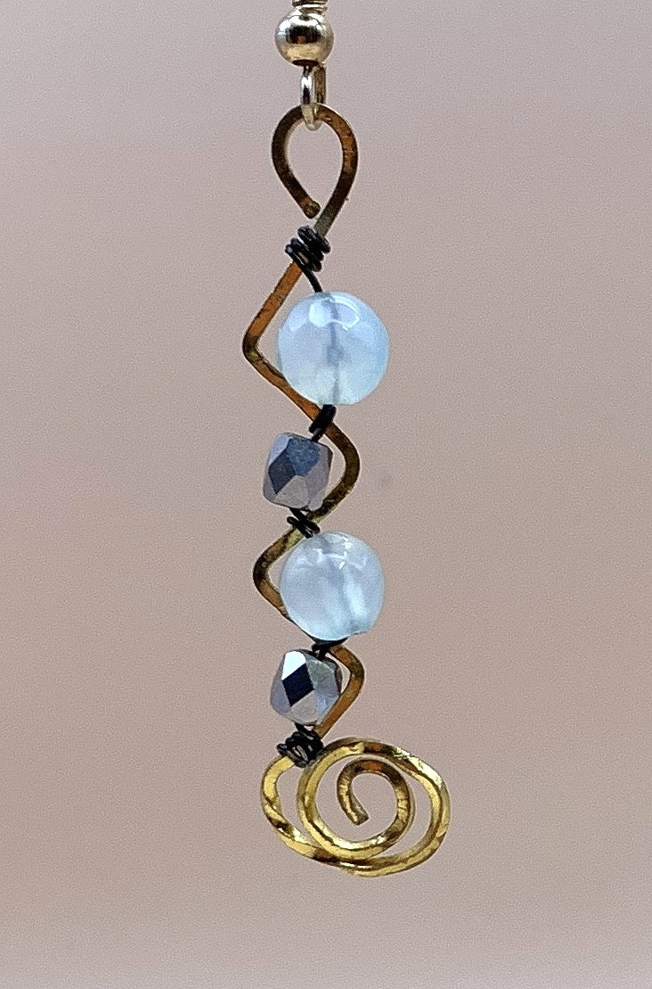 Close-up of blue round beads, faceted metallic beads and gold-tone spiral wirework