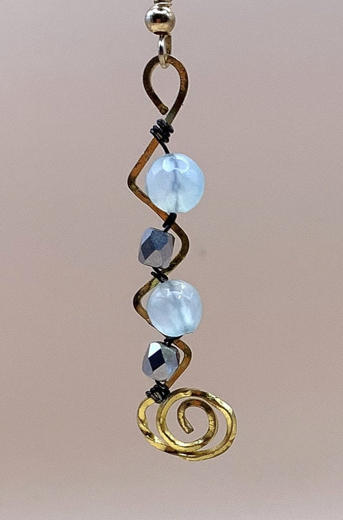 Close-up of blue round beads, faceted metallic beads and gold-tone spiral wirework