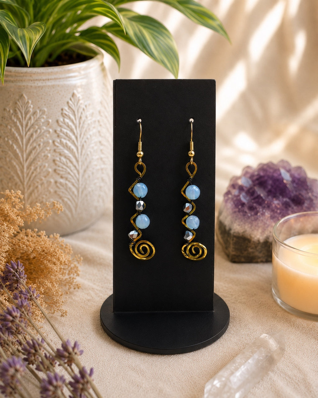 Blue spiral statement earrings styled with amethyst, quartz, dried flowers and candlelight