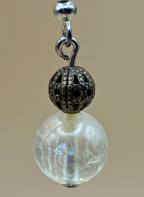 Close-up of a clear crystal bead and antique silver-tone filigree detail