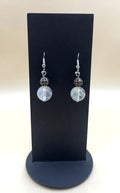 Moonlit filigree crystal drop earrings on a black display stand