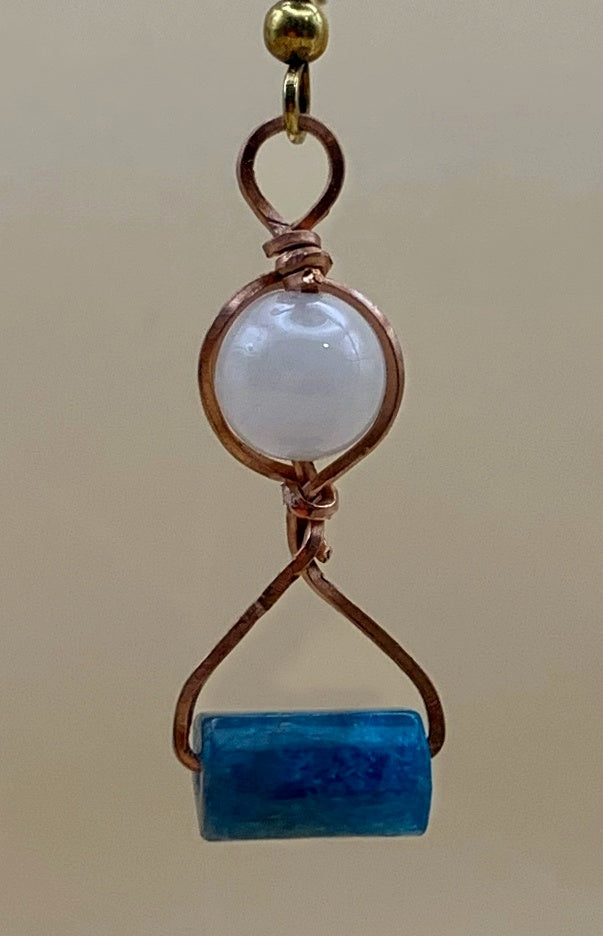 Close-up of copper wire wrapping with pale round and blue rectangular beads