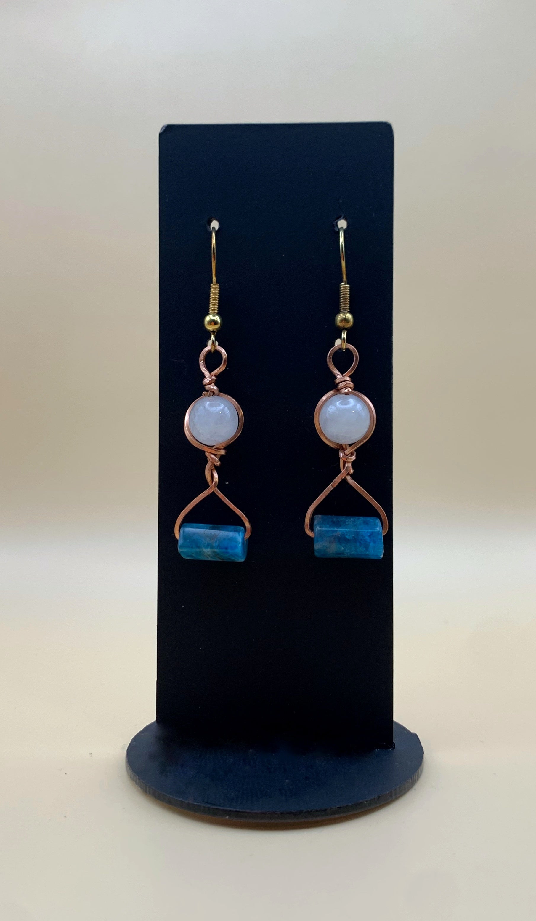 Hand-wrapped copper earrings with pale round beads and blue rectangular beads
